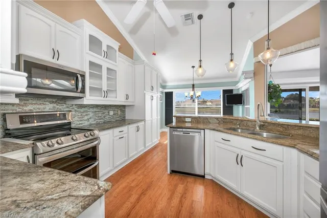 a kitchen with stainless steel appliances granite countertop a stove and cabinets
