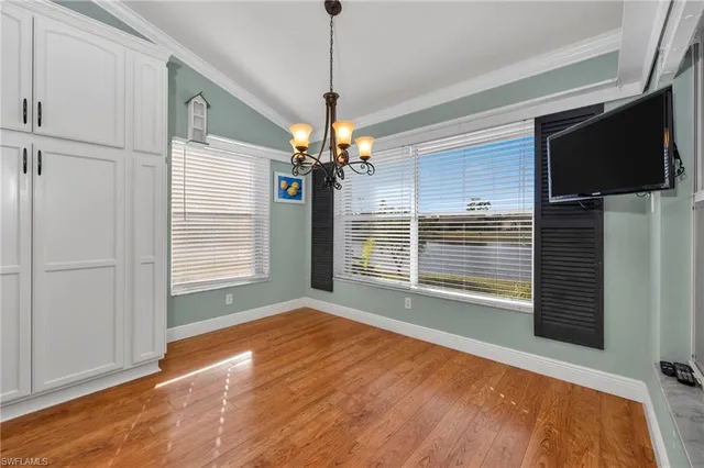 a view of an empty room with a window and a kitchen