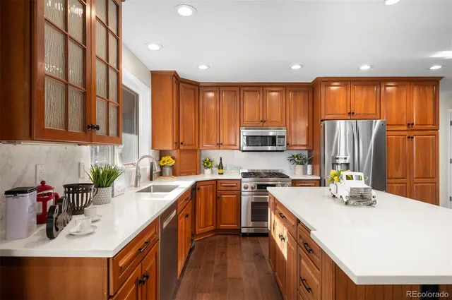 a kitchen with kitchen island granite countertop a sink a counter top space appliances and cabinets