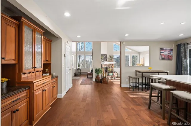 a large living room with stainless steel appliances granite countertop a couch a stove a dining table and chairs with wooden floor