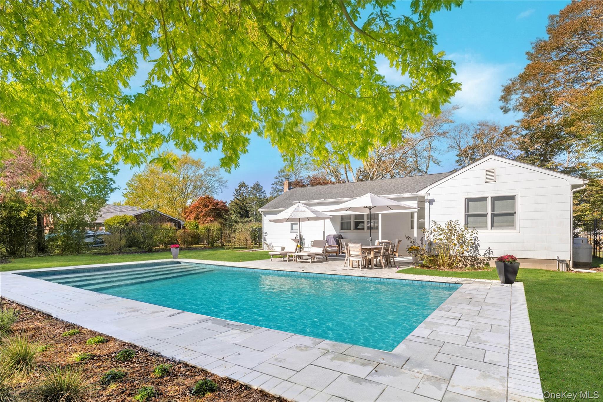 a front view of a house with a yard and trees