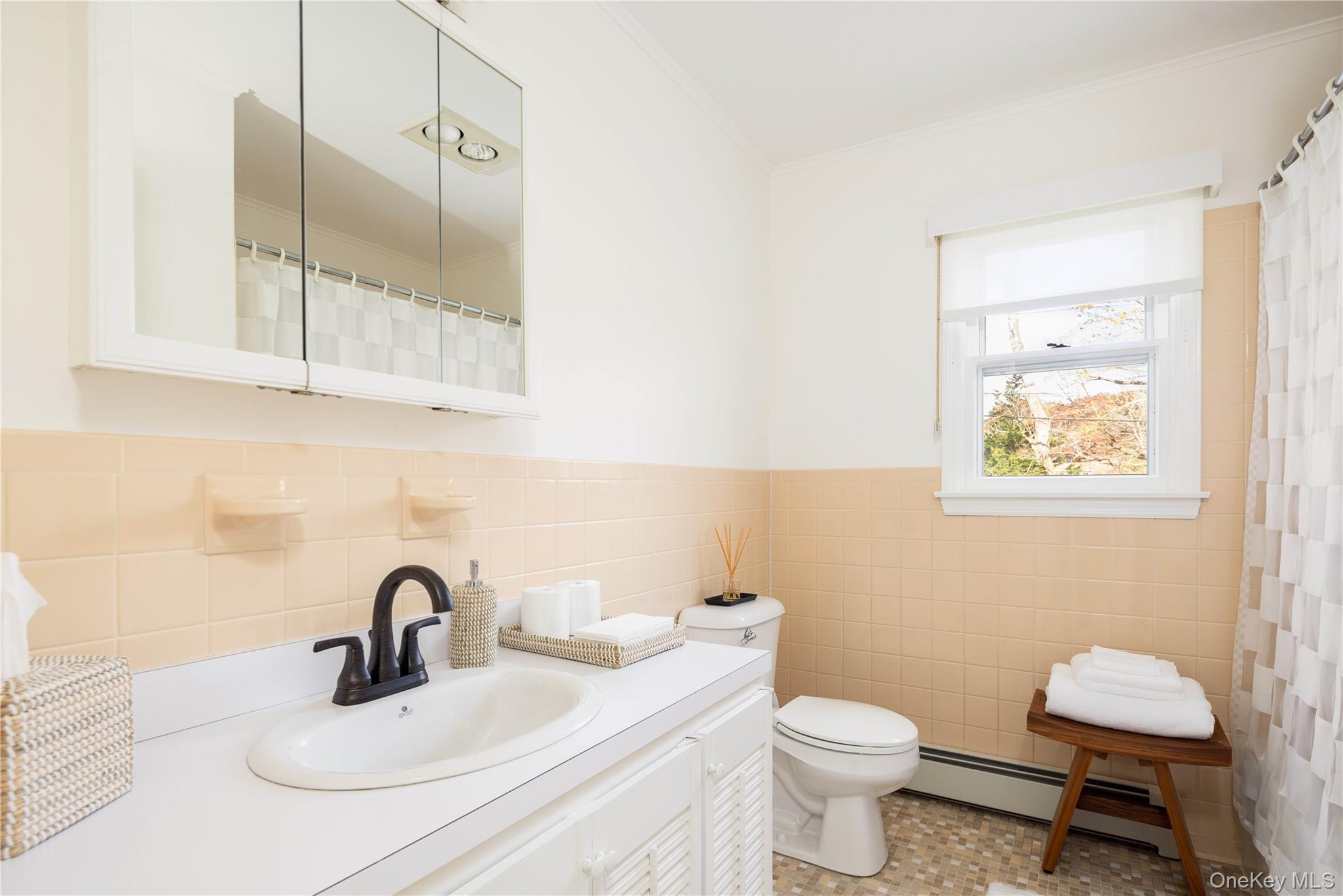 920 Pine Neck Road Southold, NY 11971 - Photo 13 of 28 a bathroom with a toilet sink and mirror