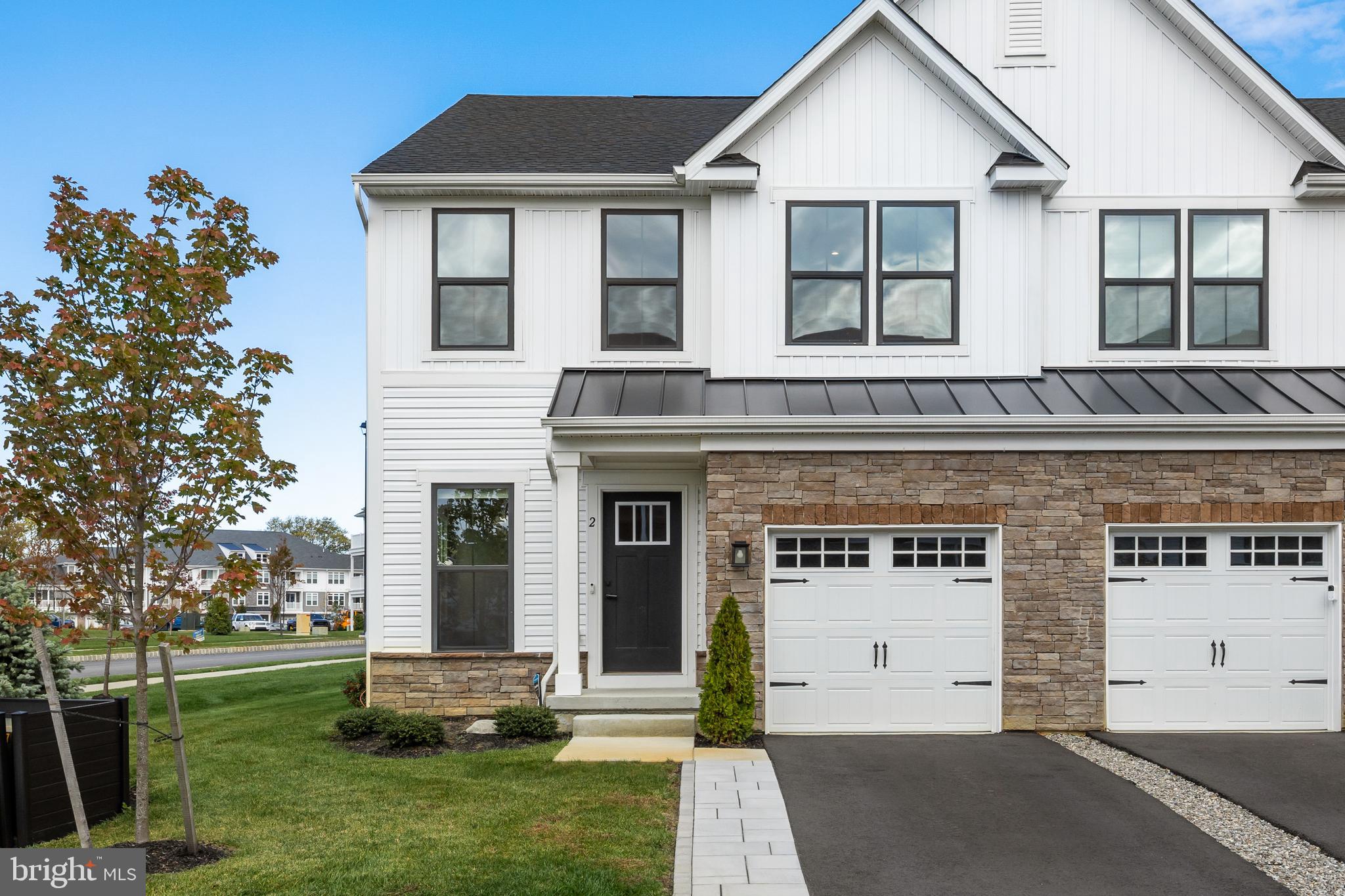 a front view of a house with a garden and plants