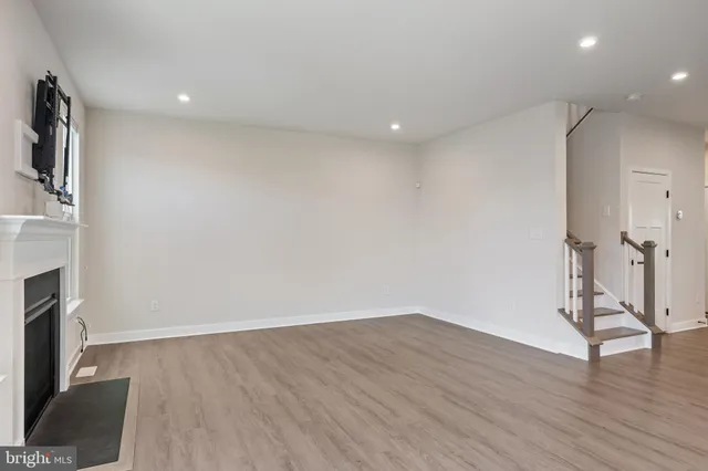 a view of a room with wooden floor and a fireplace