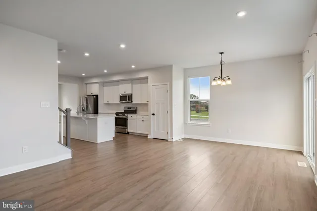 a view of kitchen with refrigerator microwave and wooden floor