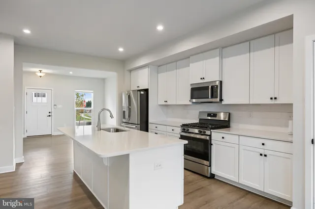 a kitchen with appliances a sink and cabinets