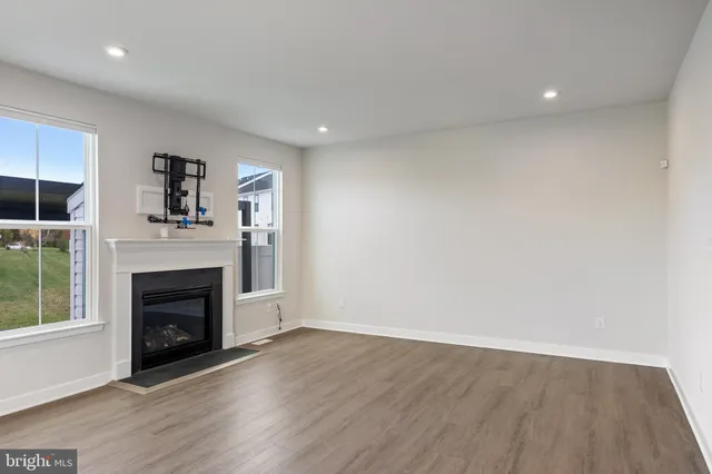 an empty room with wooden floor and fireplace