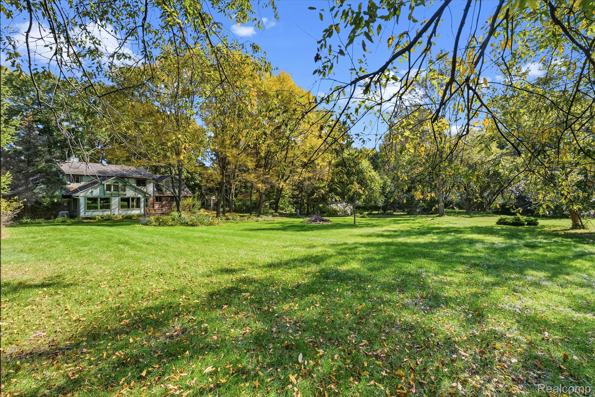 8135 Ranch Estates Road Clarkston, MI 48348 - Photo 45 of 53 Expansive green lawn with mature trees and a multi-level house exterior