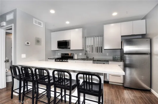 a kitchen with a table chairs refrigerator and microwave