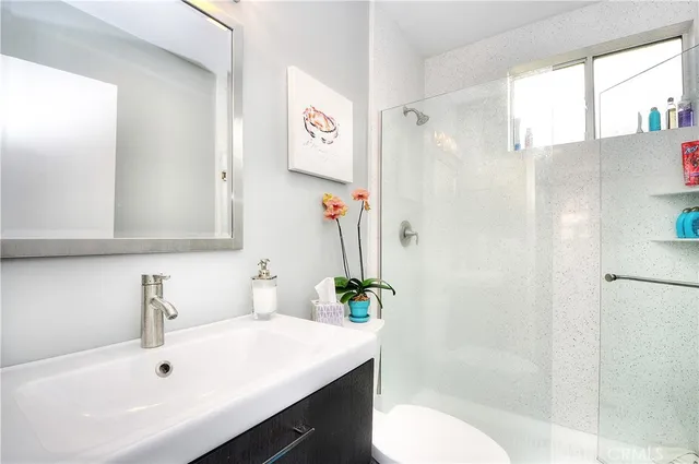 a bathroom with a sink a toilet and shower