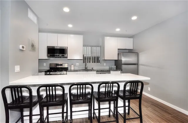 a kitchen with a table chairs refrigerator and microwave