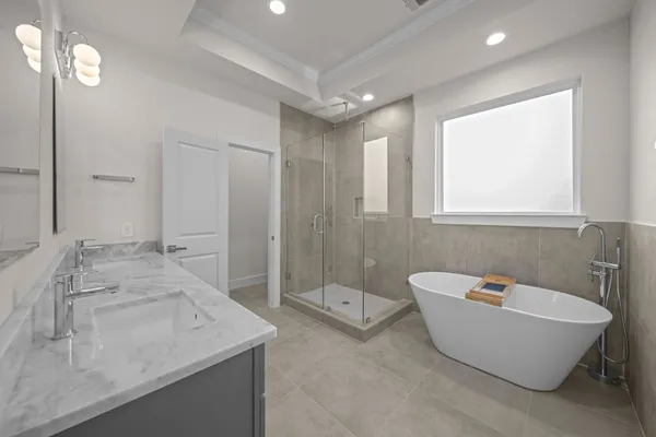 a spacious bathroom with a bathtub sink and mirror