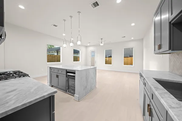 a kitchen with stainless steel appliances granite countertop stove top oven and cabinets