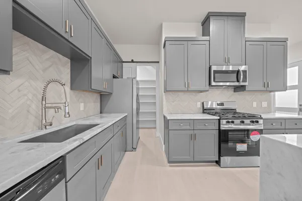 a kitchen with stainless steel appliances granite countertop a sink stove and refrigerator