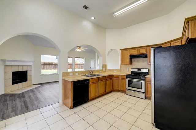 a kitchen with stainless steel appliances granite countertop a stove a sink and a refrigerator