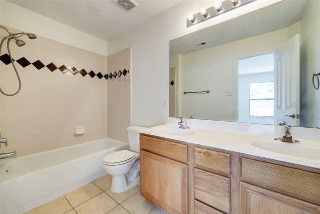 a spacious bathroom with a granite countertop sink a toilet and a bathtub