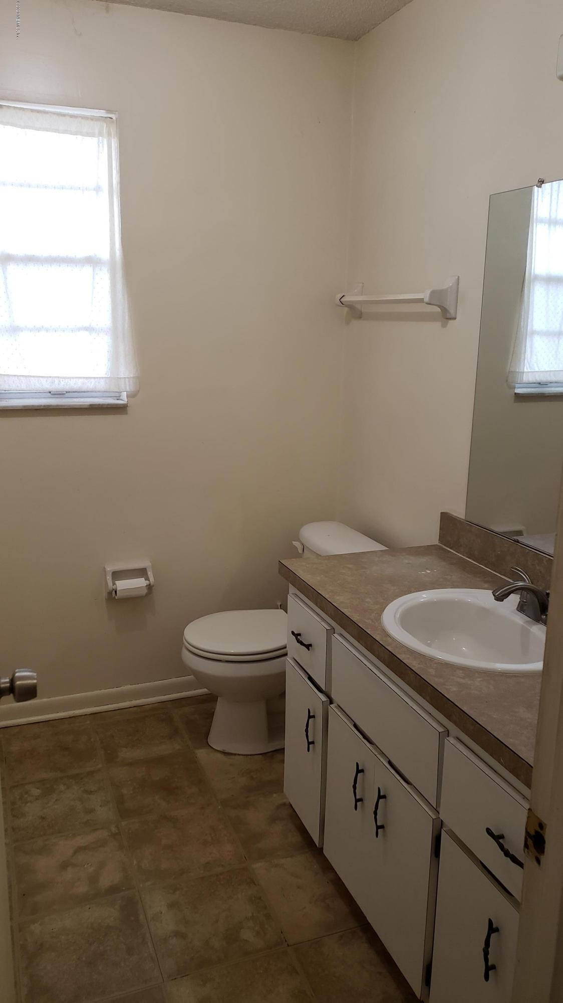 7208 Parker School Road, Unit 7 Jacksonville, FL 32211 - Photo 10 of 15 a bathroom with a granite countertop toilet and a sink
