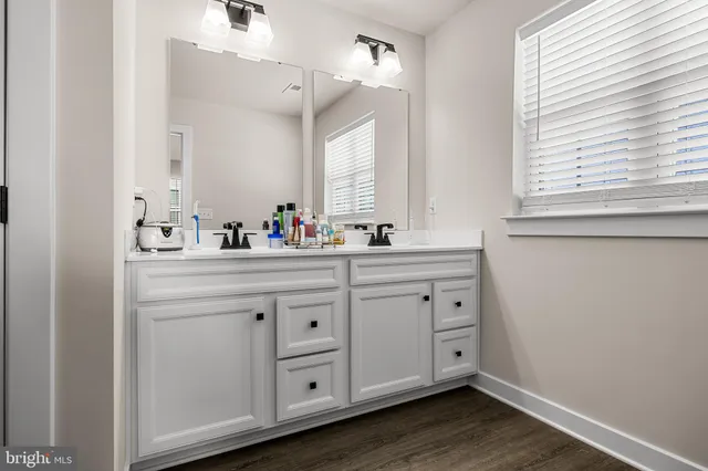 a bathroom with a double vanity sink window and a mirror