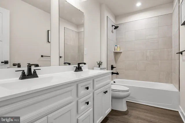 a bathroom with a double vanity sink toilet and shower
