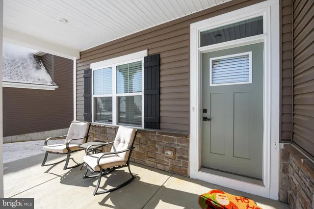 a patio with table and chairs and potted plants