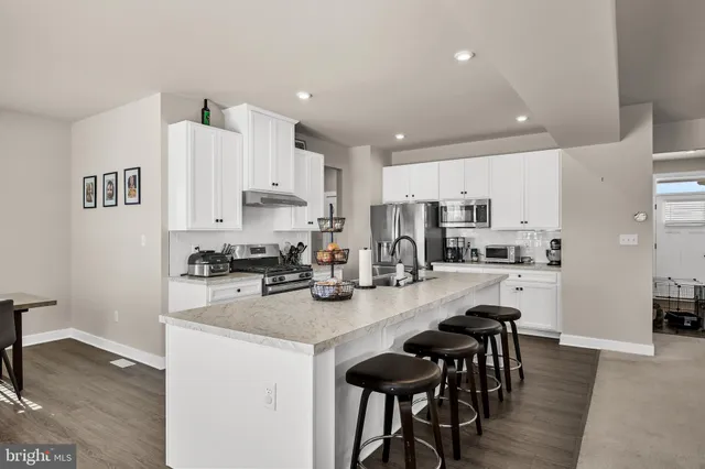 a kitchen with kitchen island granite countertop a center island and appliances