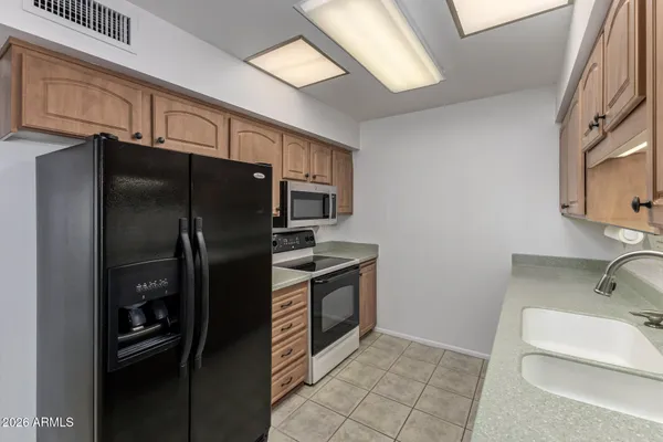 a kitchen with stainless steel appliances a sink a stove cabinets and a microwave oven