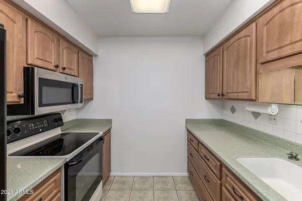 a kitchen with stainless steel appliances a sink cabinets and a counter top space