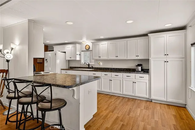 a kitchen with granite countertop white cabinets and stainless steel appliances