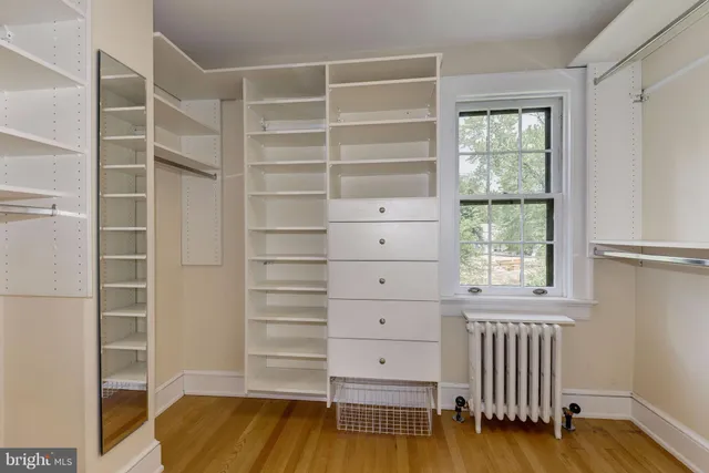 a view of walk in closet with empty racks