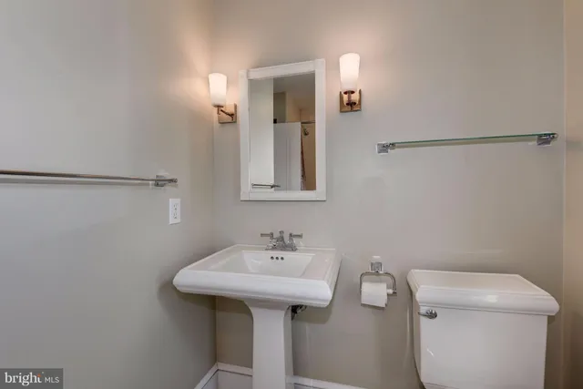 a bathroom with a sink a toilet and mirror