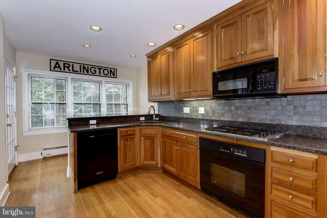 a kitchen with granite countertop wooden cabinets and a stove top oven