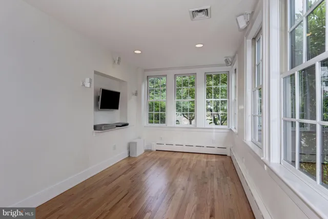 a view of a room with wooden floor and a window