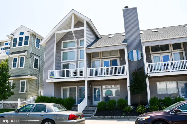 a front view of a building with car parked