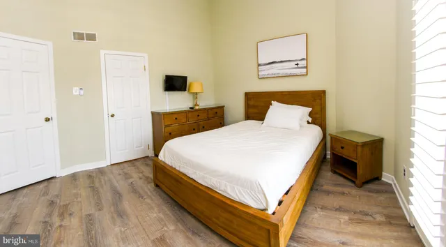a bedroom with a bed and wooden floor