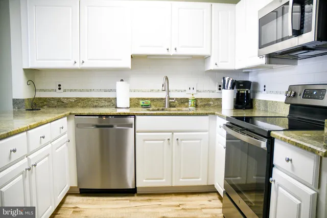 a kitchen with stainless steel appliances granite countertop a sink and cabinets