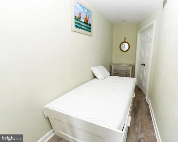 a bedroom with a bed and a painting on the wall