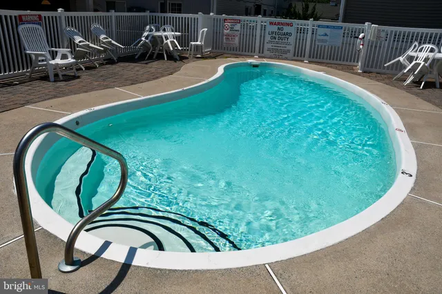 a view of a swimming pool with a patio and a chairs