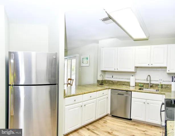 a kitchen with a refrigerator a sink and cabinets