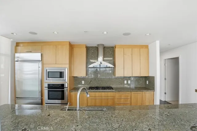 a kitchen with stainless steel appliances granite countertop a stove a sink and a refrigerator