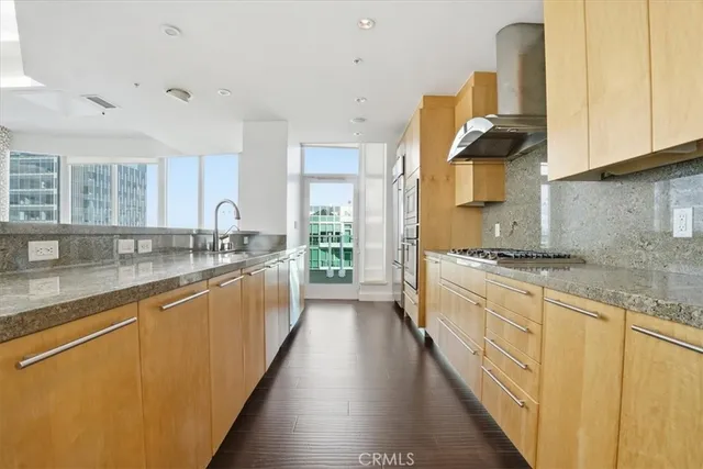 a large kitchen with stainless steel appliances granite countertop a lot of counter space and a sink
