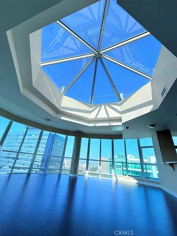 a view of an empty room with windows and ceiling fan