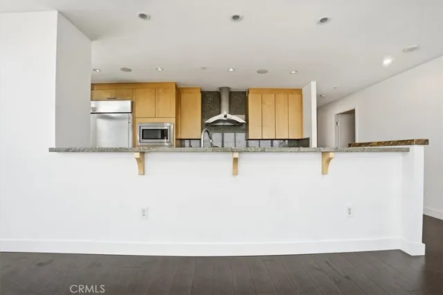 a view of kitchen with stainless steel appliances kitchen island sink and refrigerator