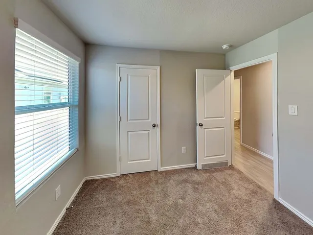 an empty room with windows and closet