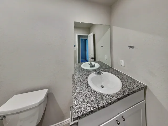 a bathroom with a granite countertop sink and a mirror