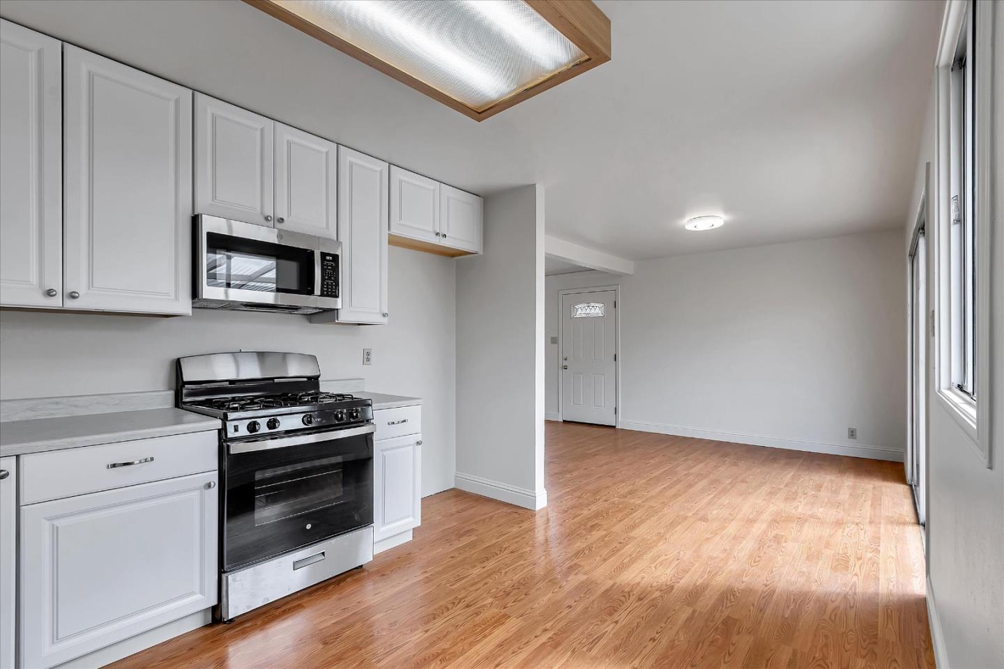 728 Arguello Boulevard Pacifica, CA 94044 - Photo 14 of 34 a kitchen with granite countertop a stove a microwave and a hard wood floors