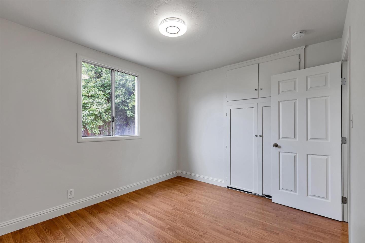 728 Arguello Boulevard Pacifica, CA 94044 - Photo 17 of 34 an empty room with wooden floor and windows