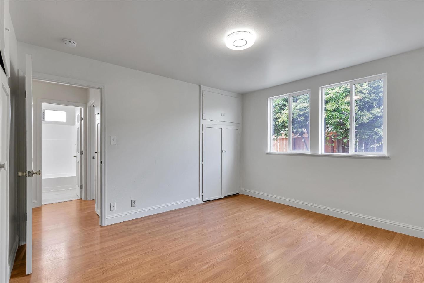 728 Arguello Boulevard Pacifica, CA 94044 - Photo 20 of 34 an empty room with wooden floor and windows