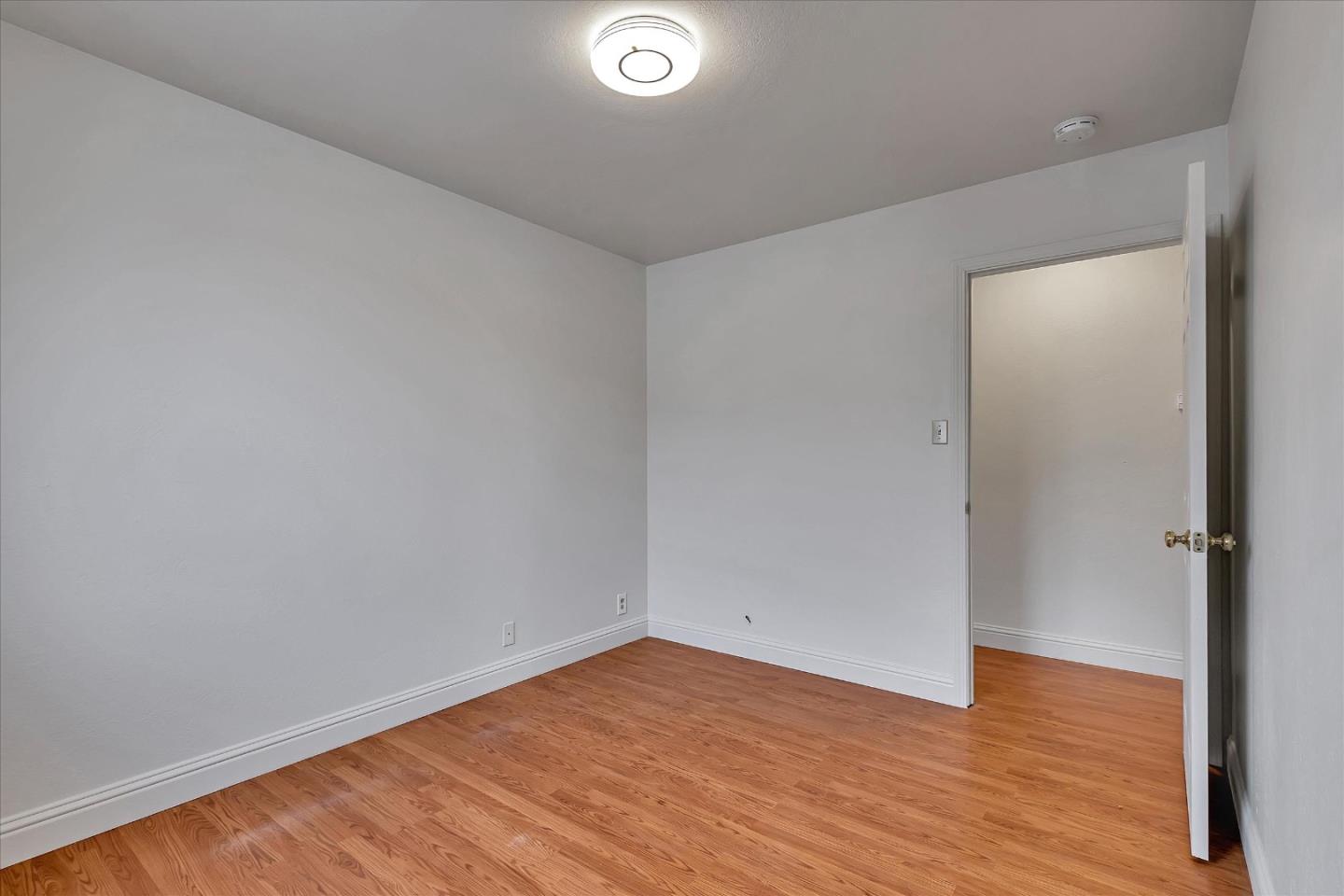 728 Arguello Boulevard Pacifica, CA 94044 - Photo 26 of 34 an empty room with wooden floor and windows