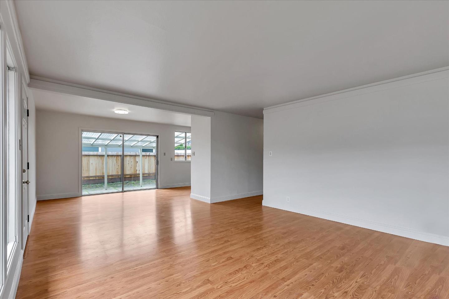 728 Arguello Boulevard Pacifica, CA 94044 - Photo 10 of 34 a view of an empty room with wooden floor and balcony
