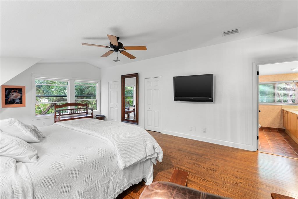 120 Beach Street Ponce Inlet, FL 32127 - Photo 41 of 91 a bedroom with a bed a tv and wooden floor